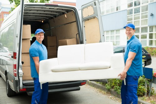 Furniture pick-up team handling a sofa collection in a Hampstead home
