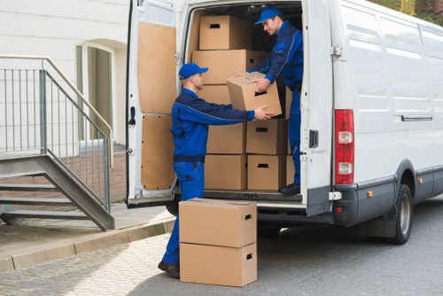 Movers carrying furniture through a Hampstead apartment entrance